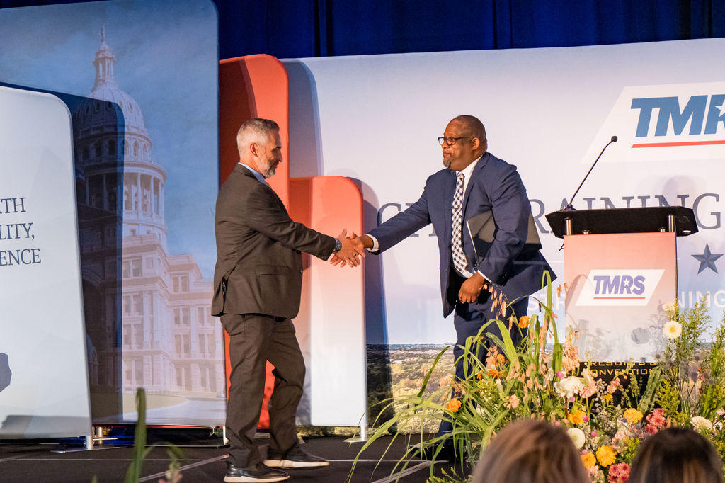 Handshake on stage between speakers at the TMRS City Training Conference