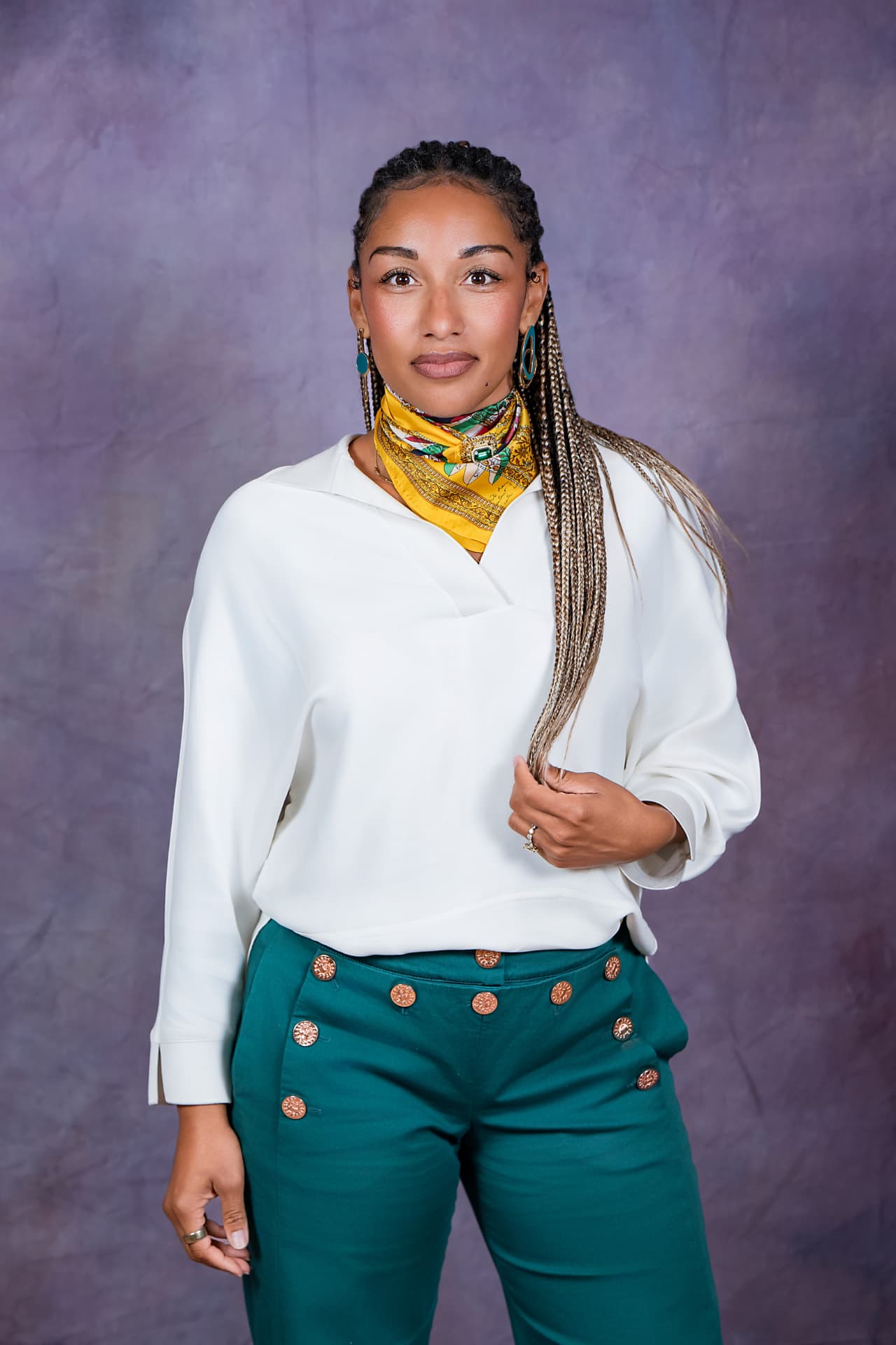 Studio portrait of a woman in a white blouse and yellow scarf