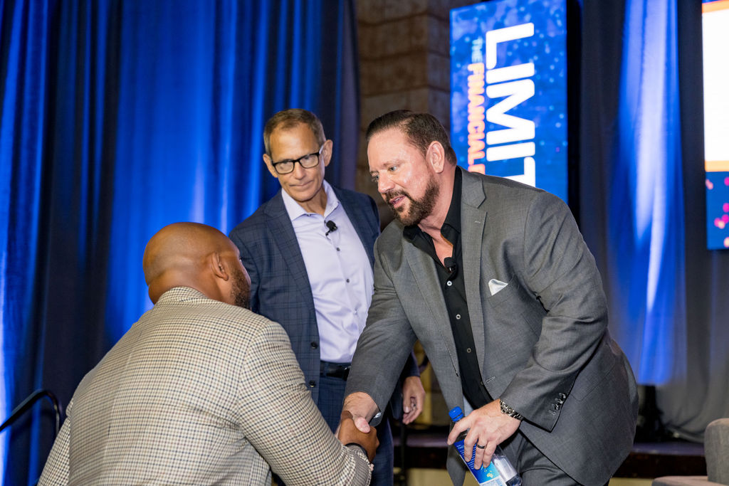 Speakers shaking hands on stage after a Limitless Expo session