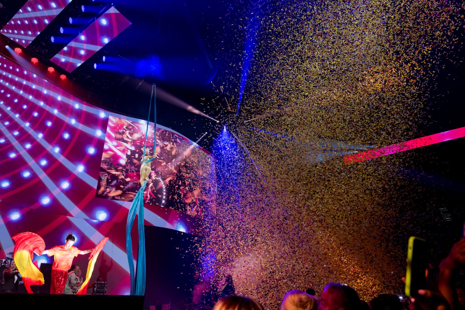Aerial silk performer and confetti cannons during a gala production number