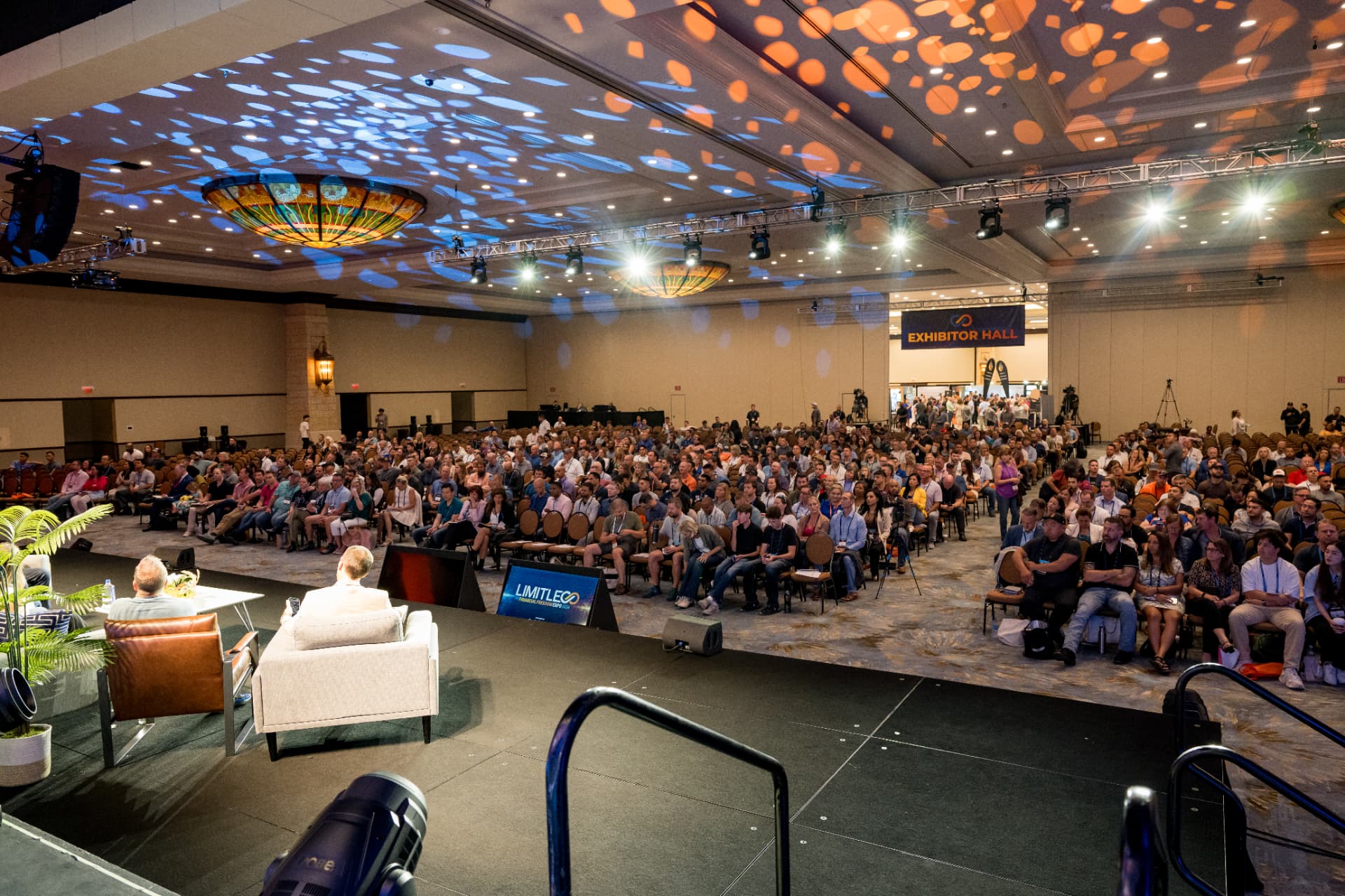 Stage-side view of a packed audience during a Limitless Expo keynote