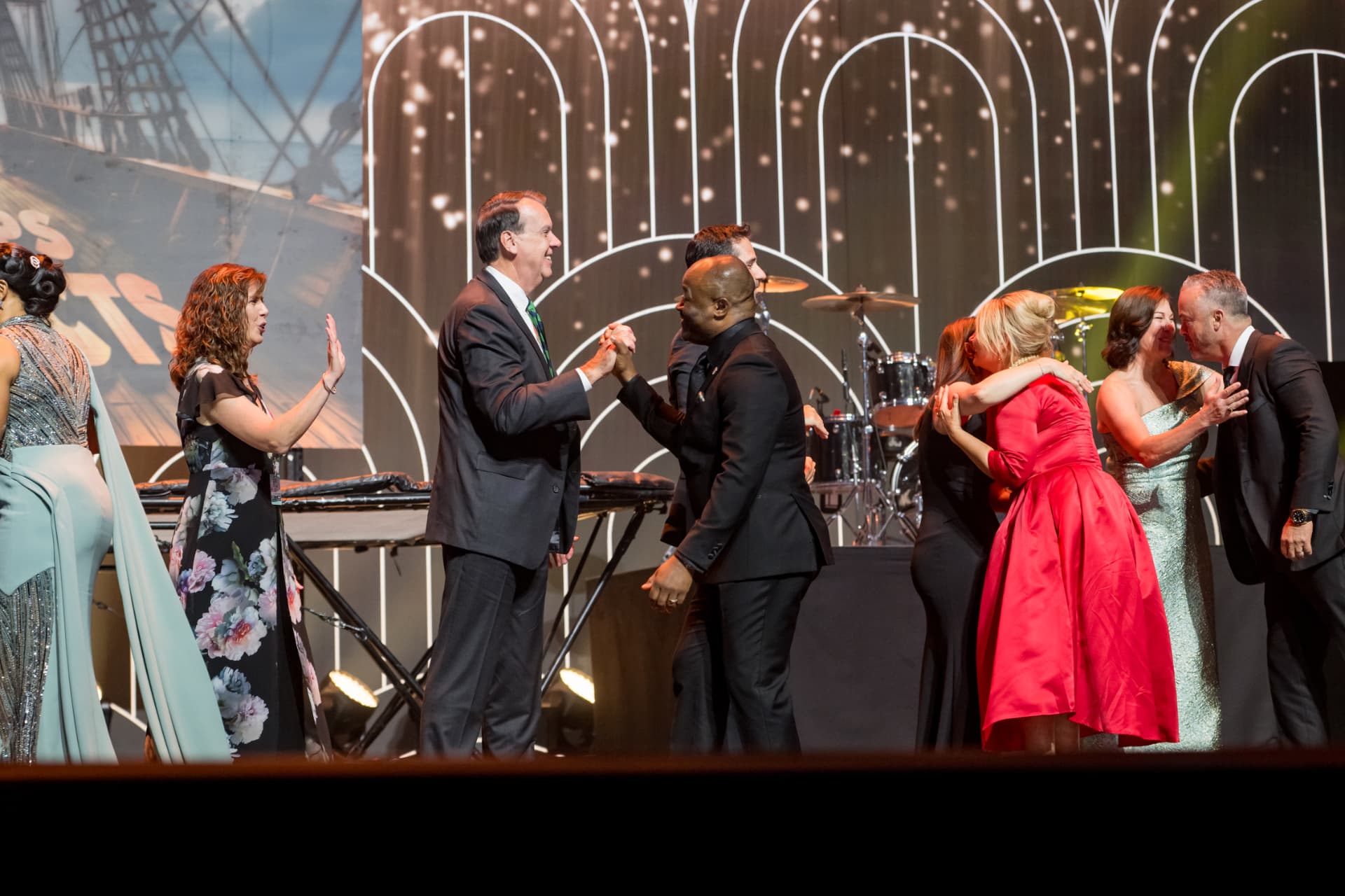 Executives greeting each other on stage during an awards presentation