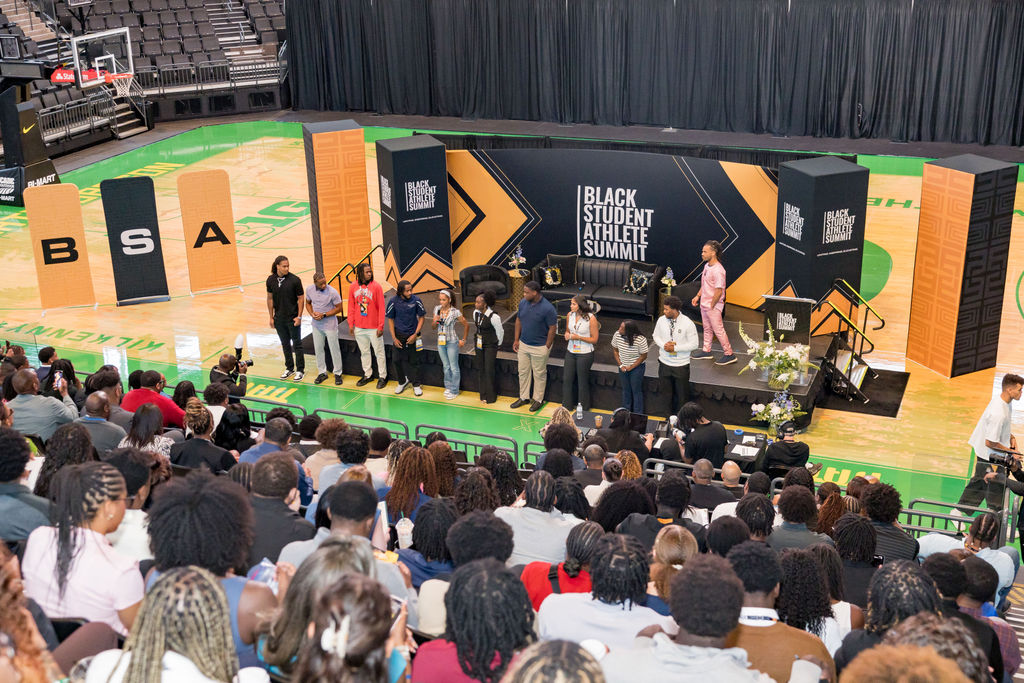 Wide view of the main stage panel in front of a packed arena