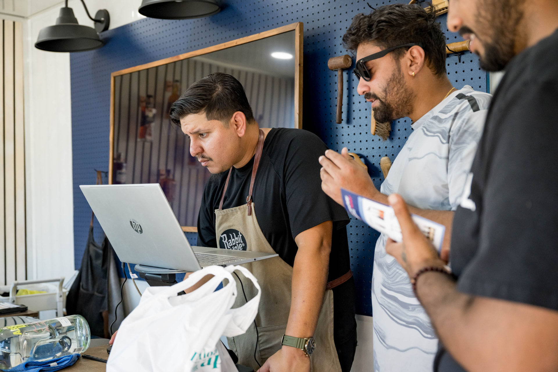 Team members reviewing an order on a laptop inside a branded pop-up studio