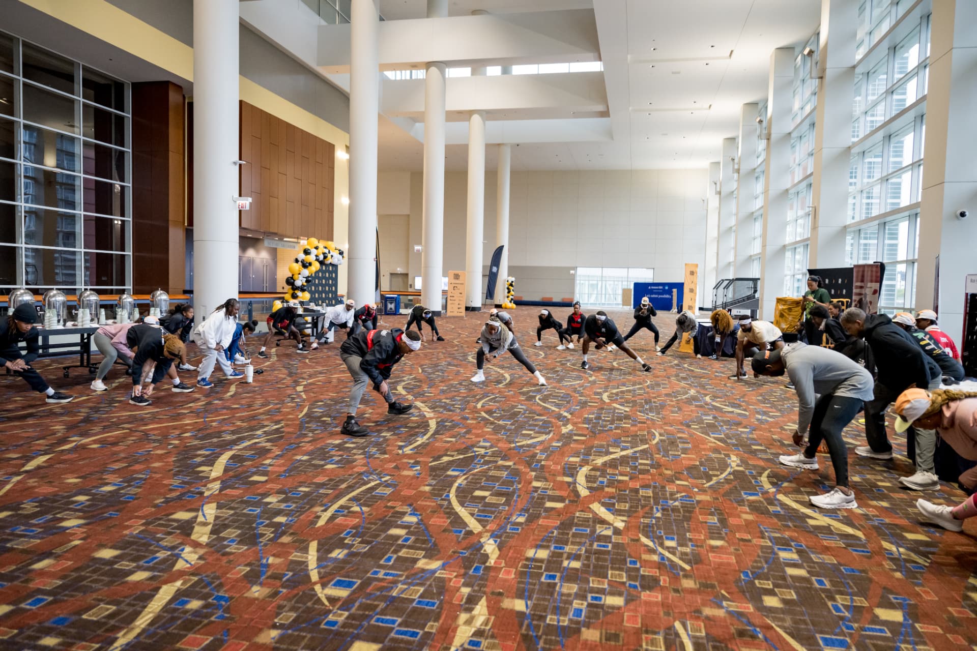 Wide view of a group stretching in a convention center hall