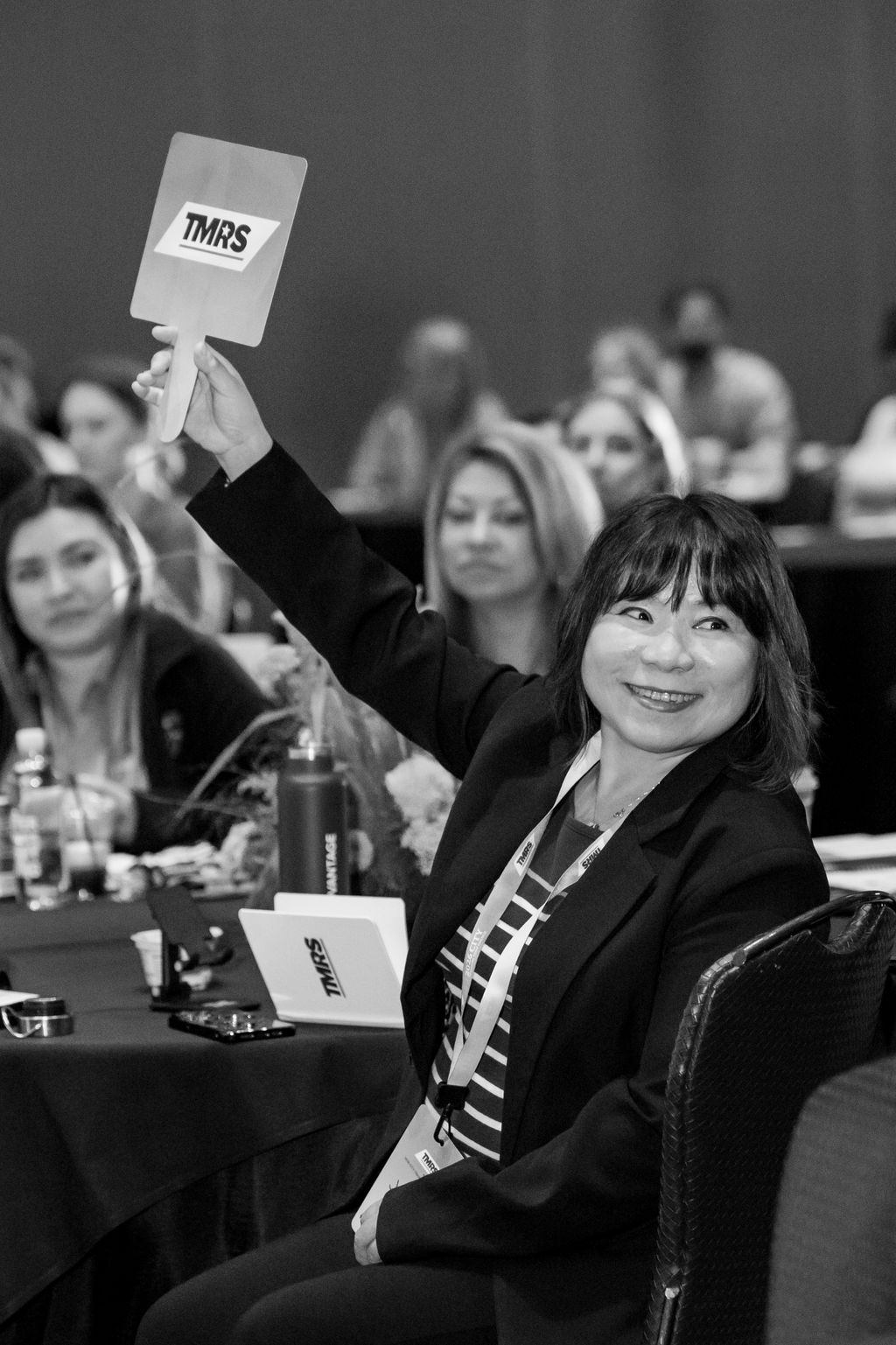 Attendee raising a TMRS voting paddle during the business session