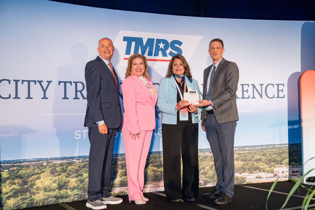 Award presentation group photo in front of the TMRS City Training Conference backdrop