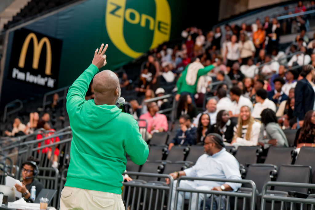 Host hyping up the arena crowd during the summit