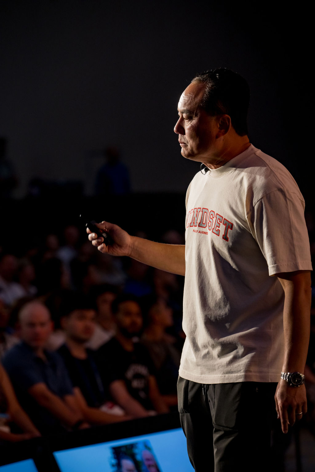 Keynote speaker walking the stage in dramatic light at Limitless Expo