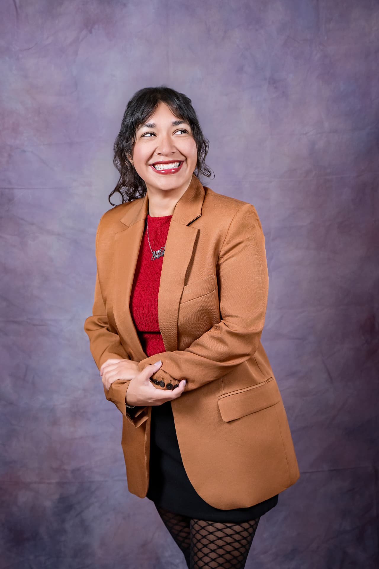 Studio portrait of a laughing woman in a camel blazer