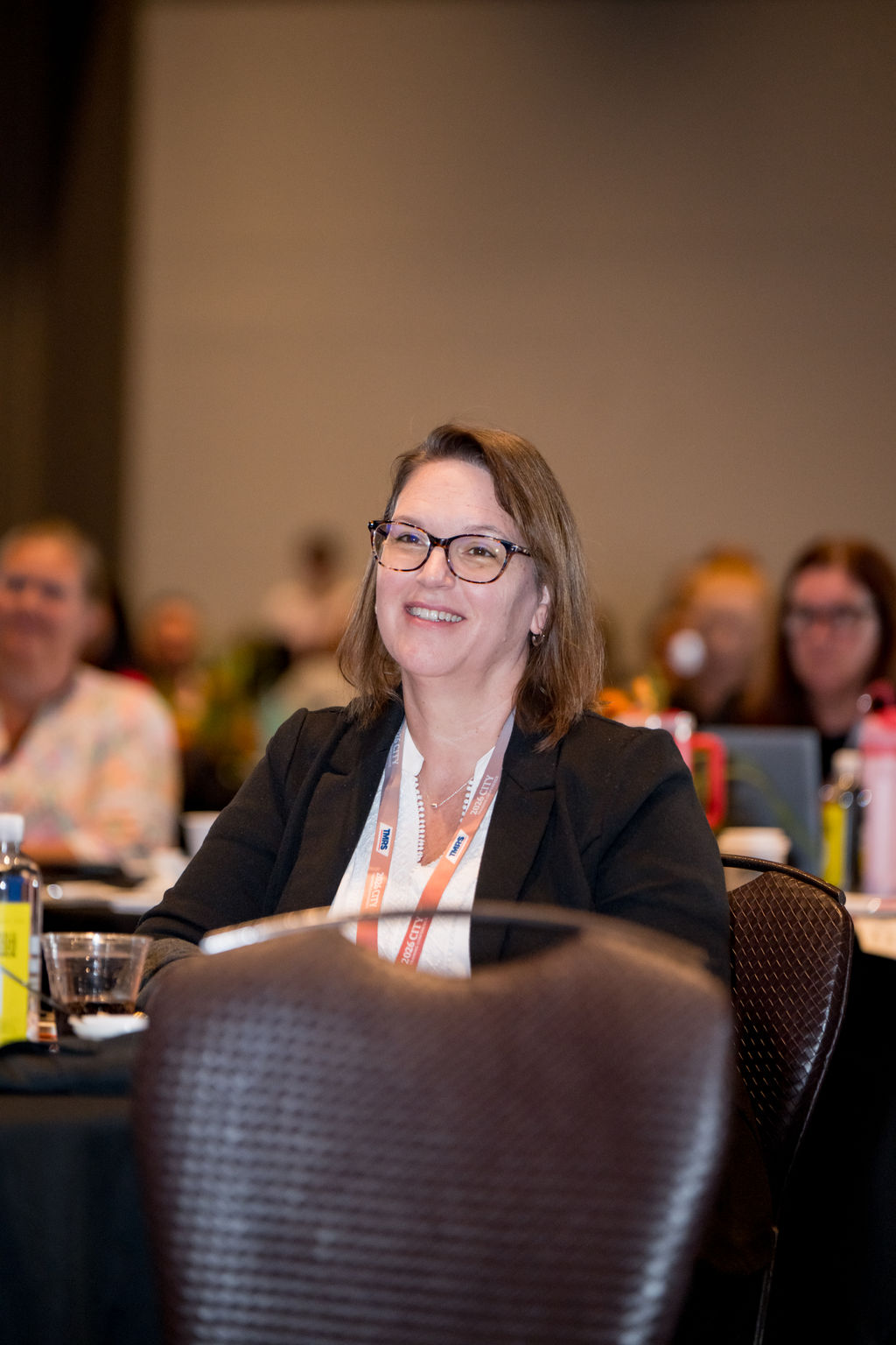 Attendee listening and smiling at a TMRS conference table