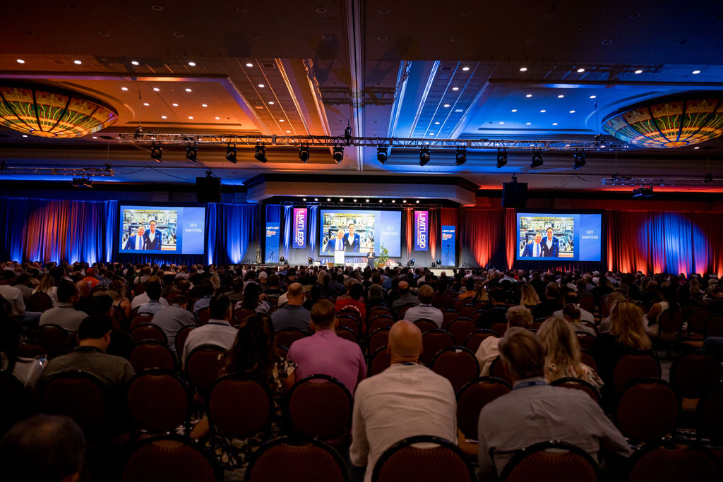 Main ballroom bathed in blue and orange light during a Limitless Expo keynote