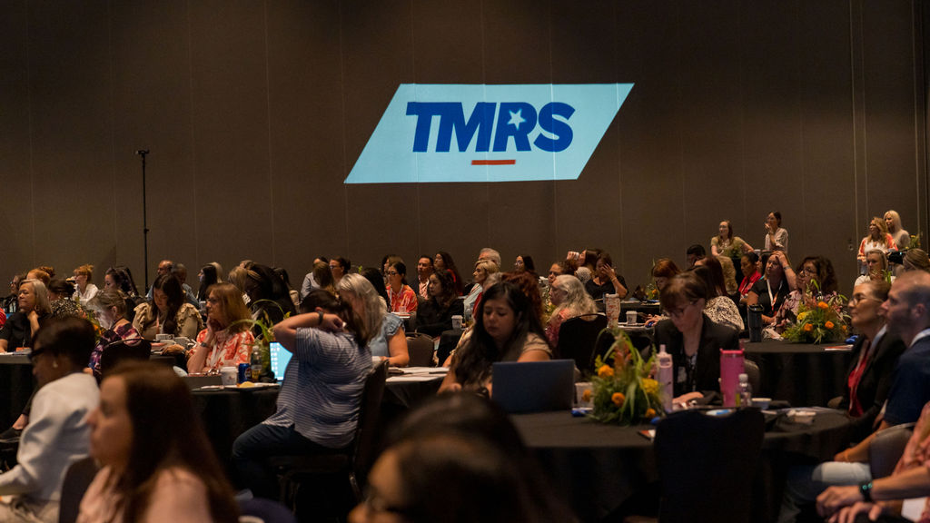 Full ballroom of attendees beneath the projected TMRS logo