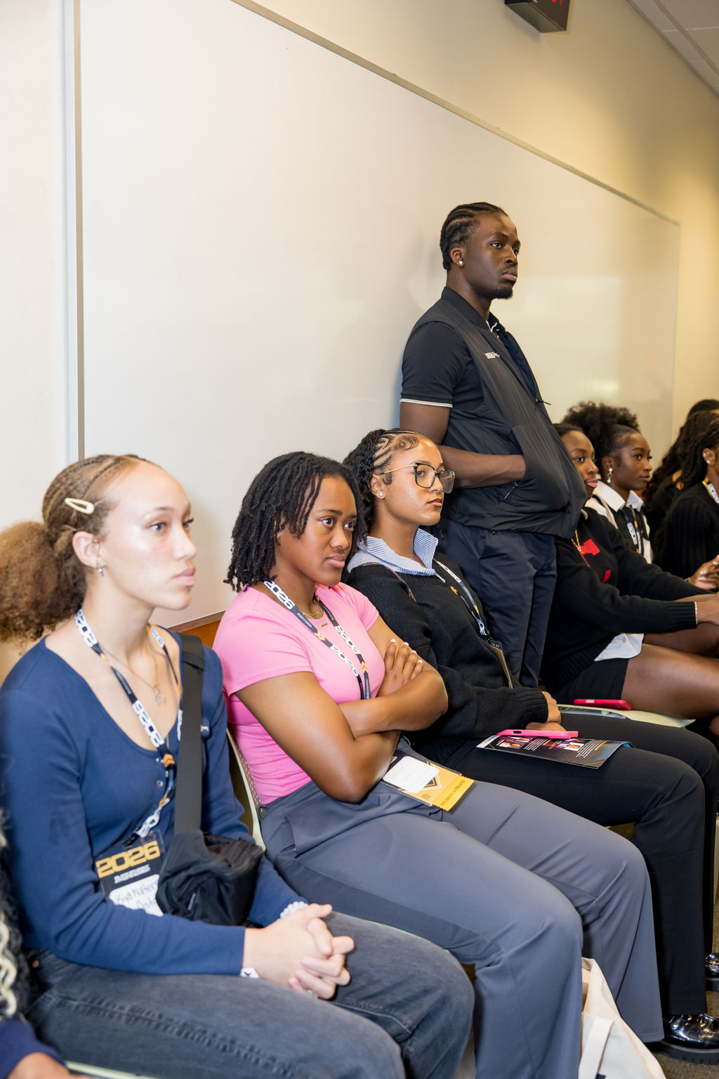Attendees listening closely along the classroom wall
