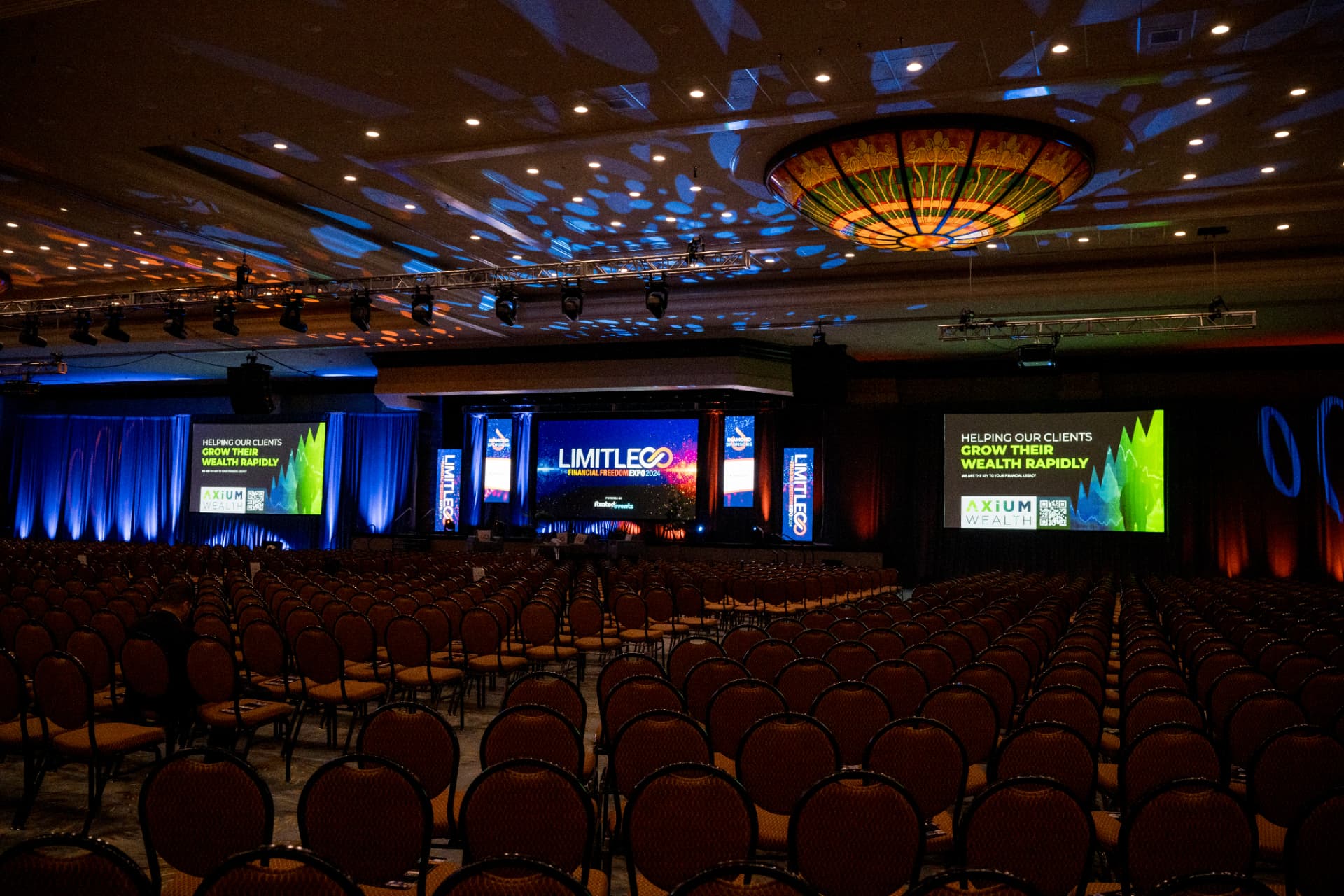 Empty ballroom set with stage graphics before a Limitless Expo session