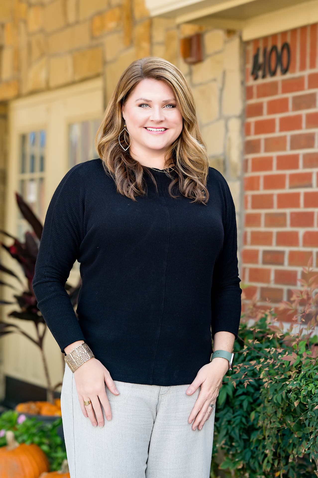 Business portrait of a woman in a black sweater outside a brick office building