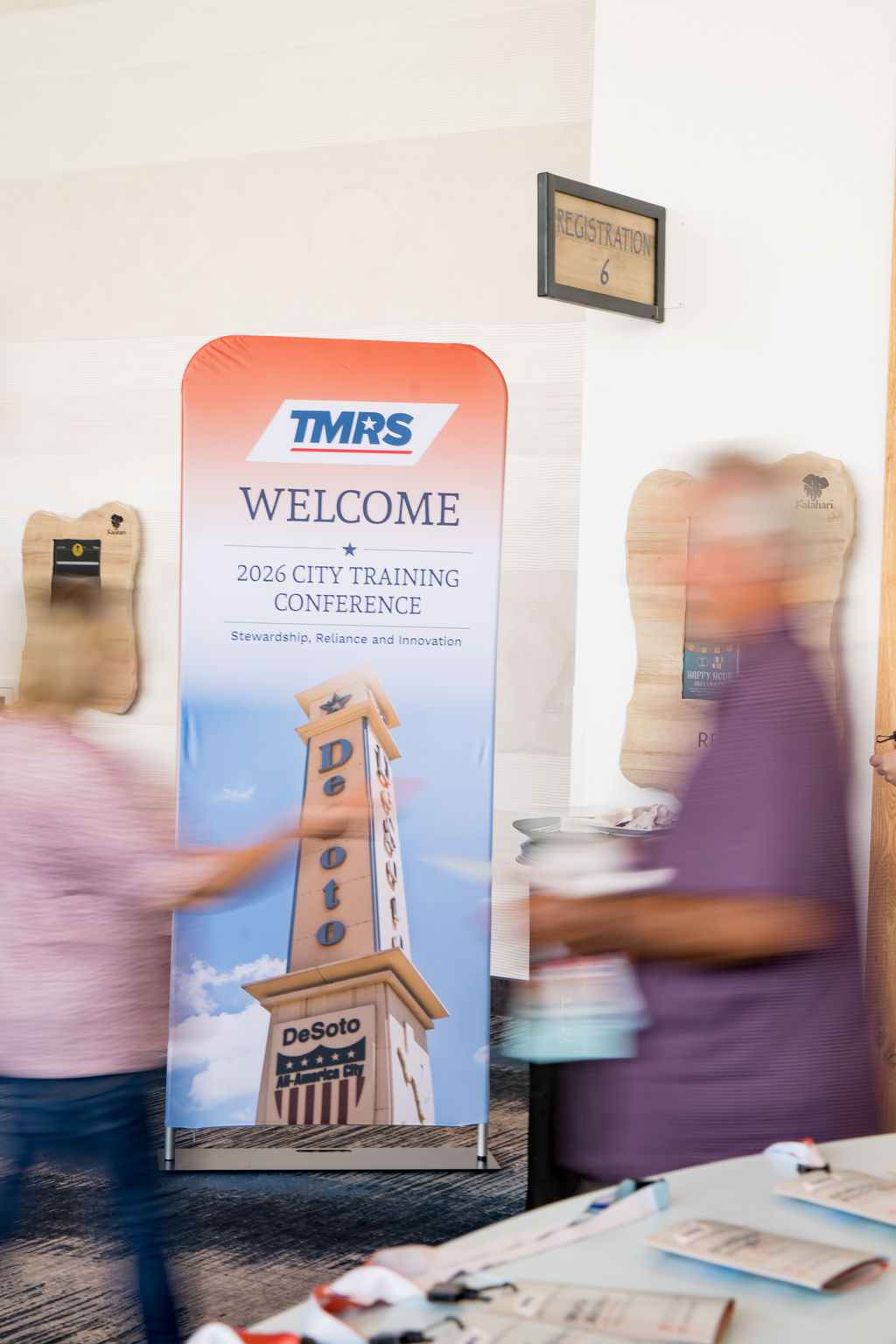 TMRS welcome banner with attendees passing by at registration