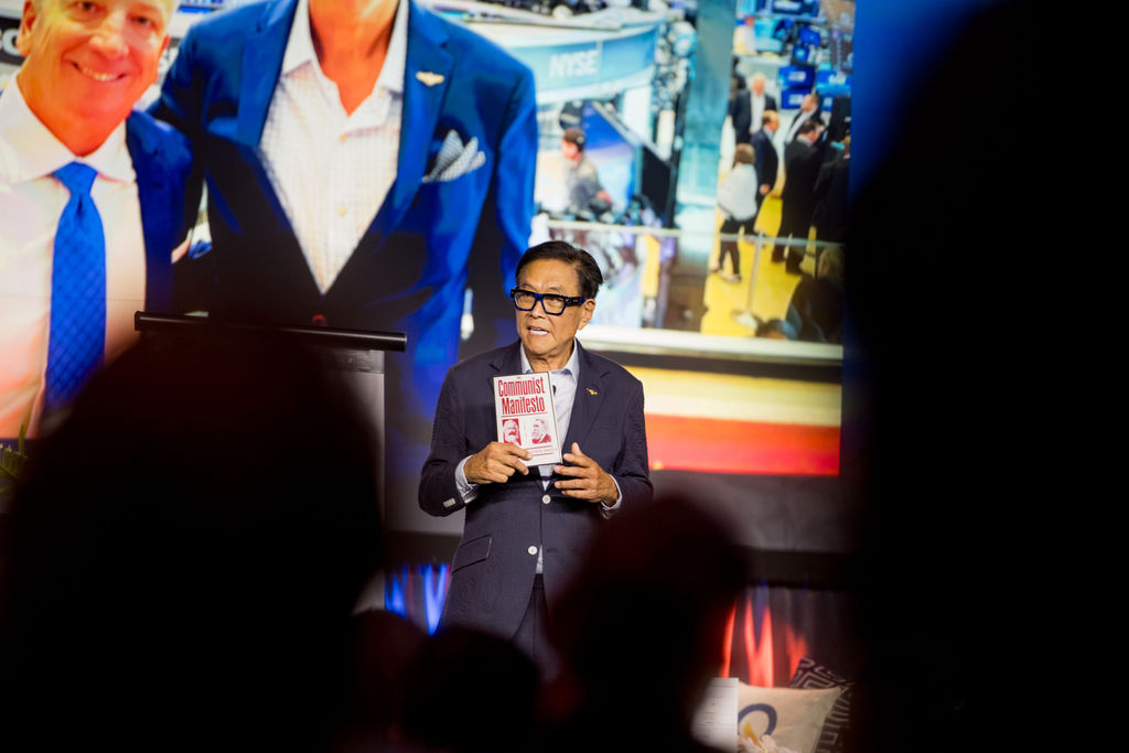 Featured speaker addressing the room framed by the audience at Limitless Expo
