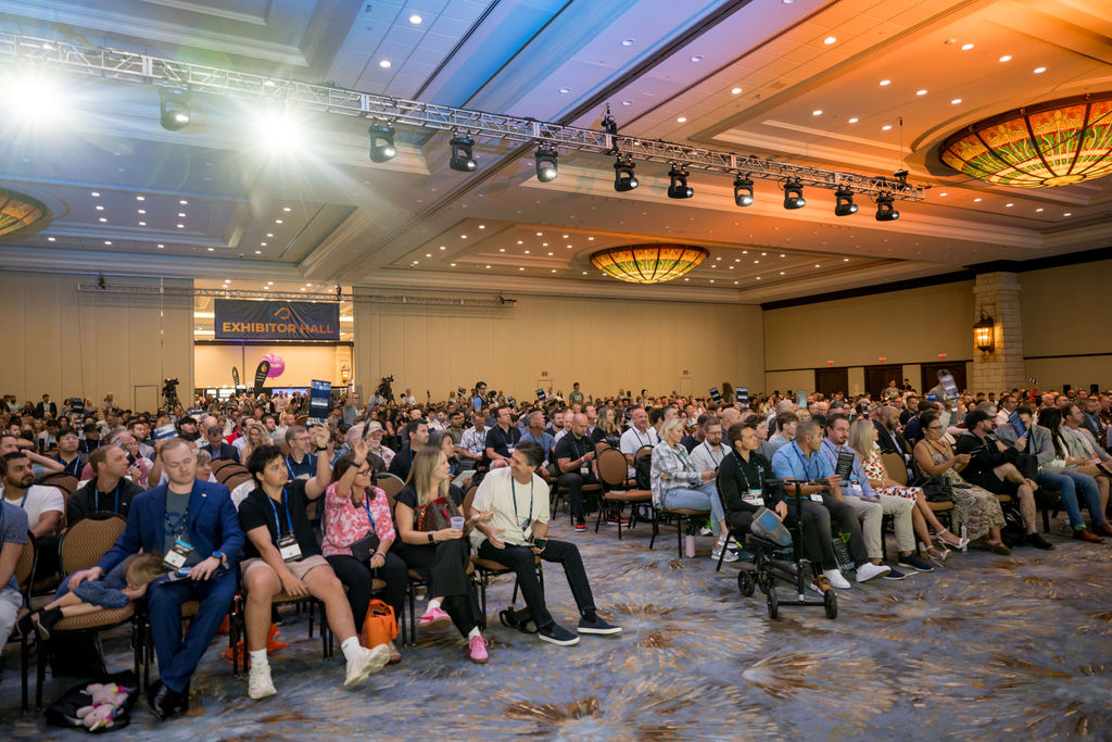 Wide view of the Limitless Expo audience under stage lighting