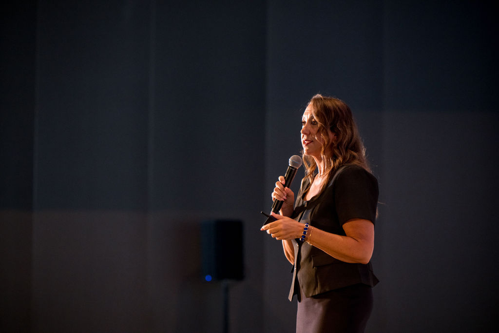 Moody stage portrait of a speaker presenting at the TMRS conference
