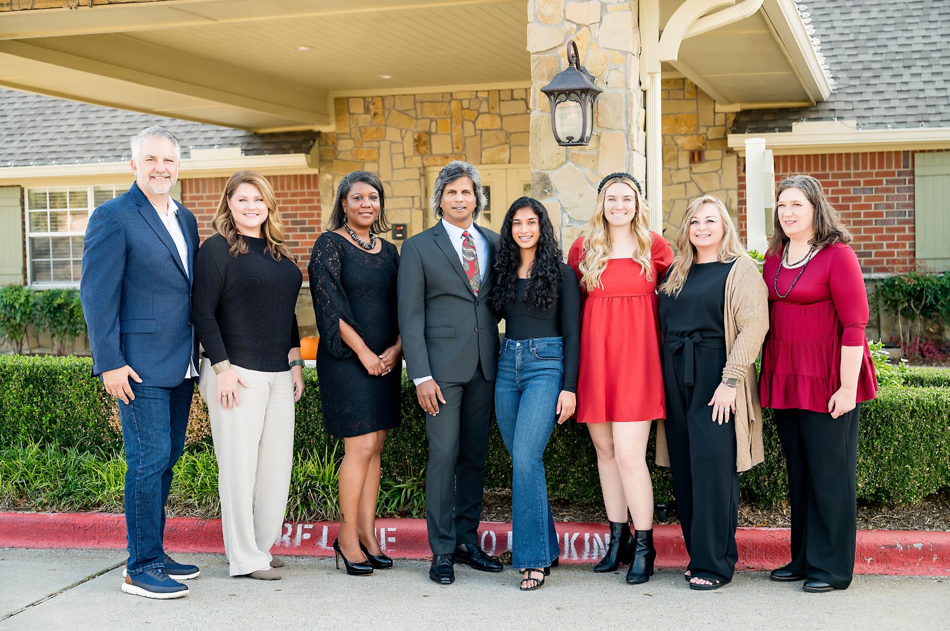Full staff team photo outside a school entrance in Dallas–Fort Worth