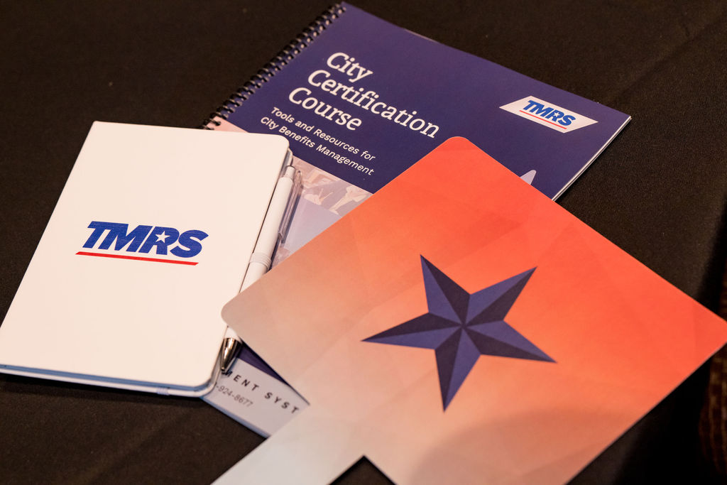 TMRS City Certification Course materials and branded notebook on a conference table