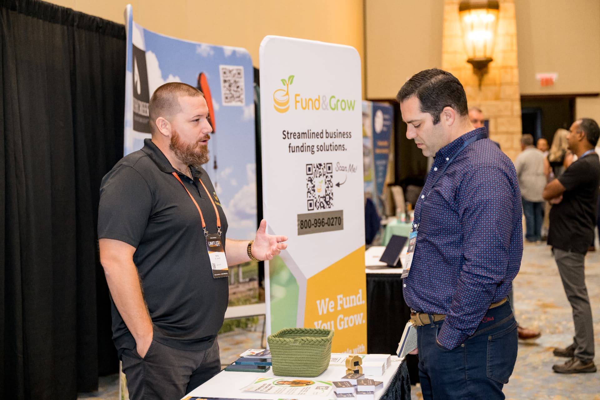 Two attendees talking at a sponsor booth on the Limitless Expo show floor