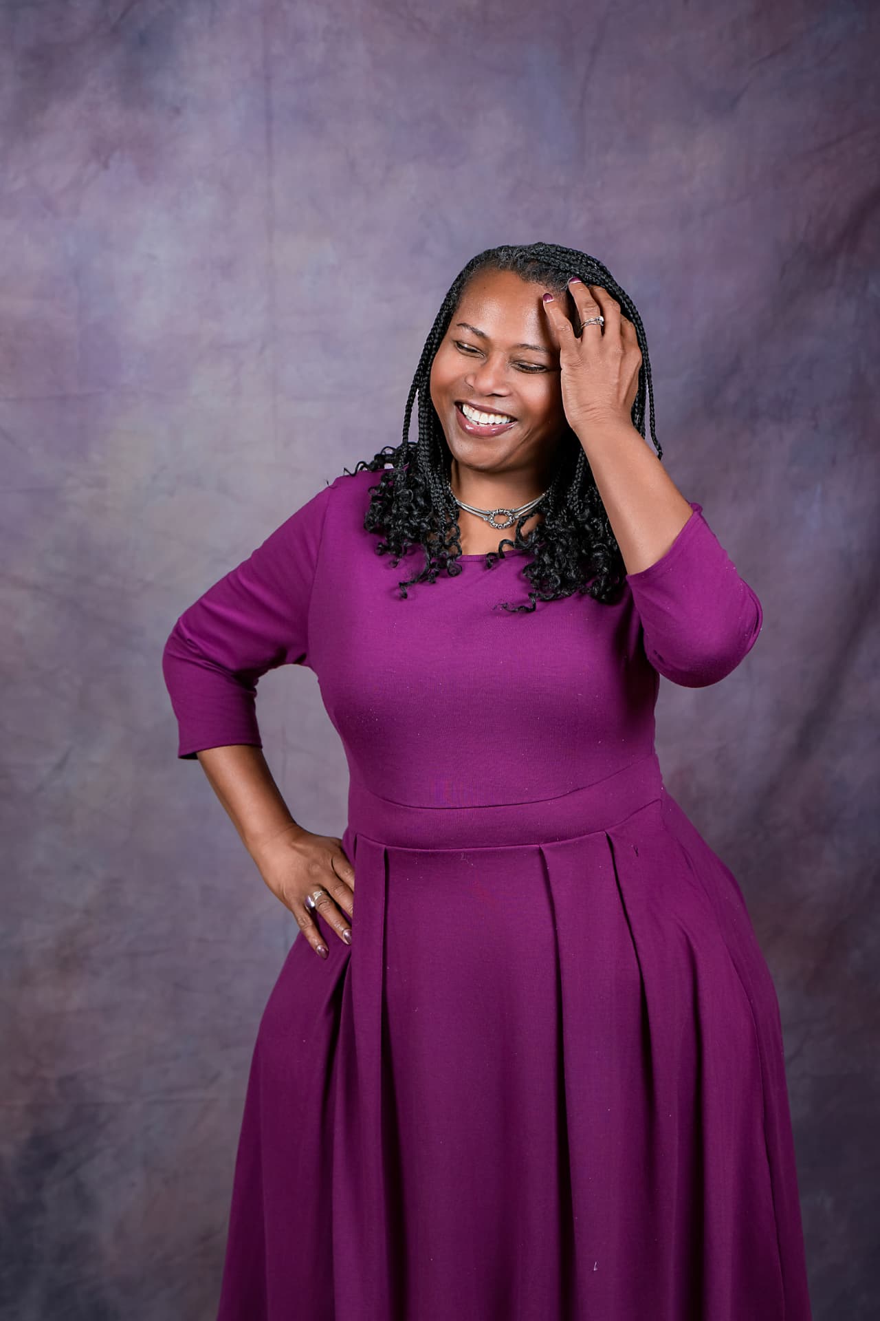 Studio portrait of a laughing woman in a magenta dress