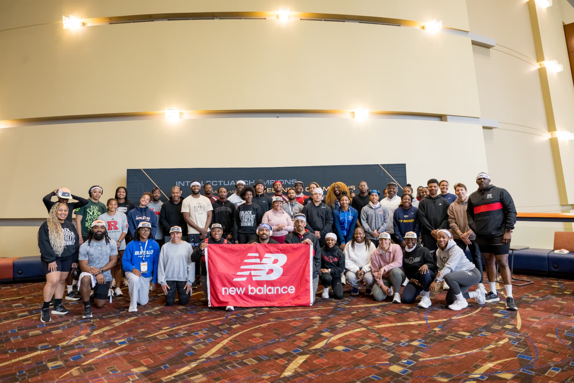 Group photo of summit attendees holding a sponsor banner