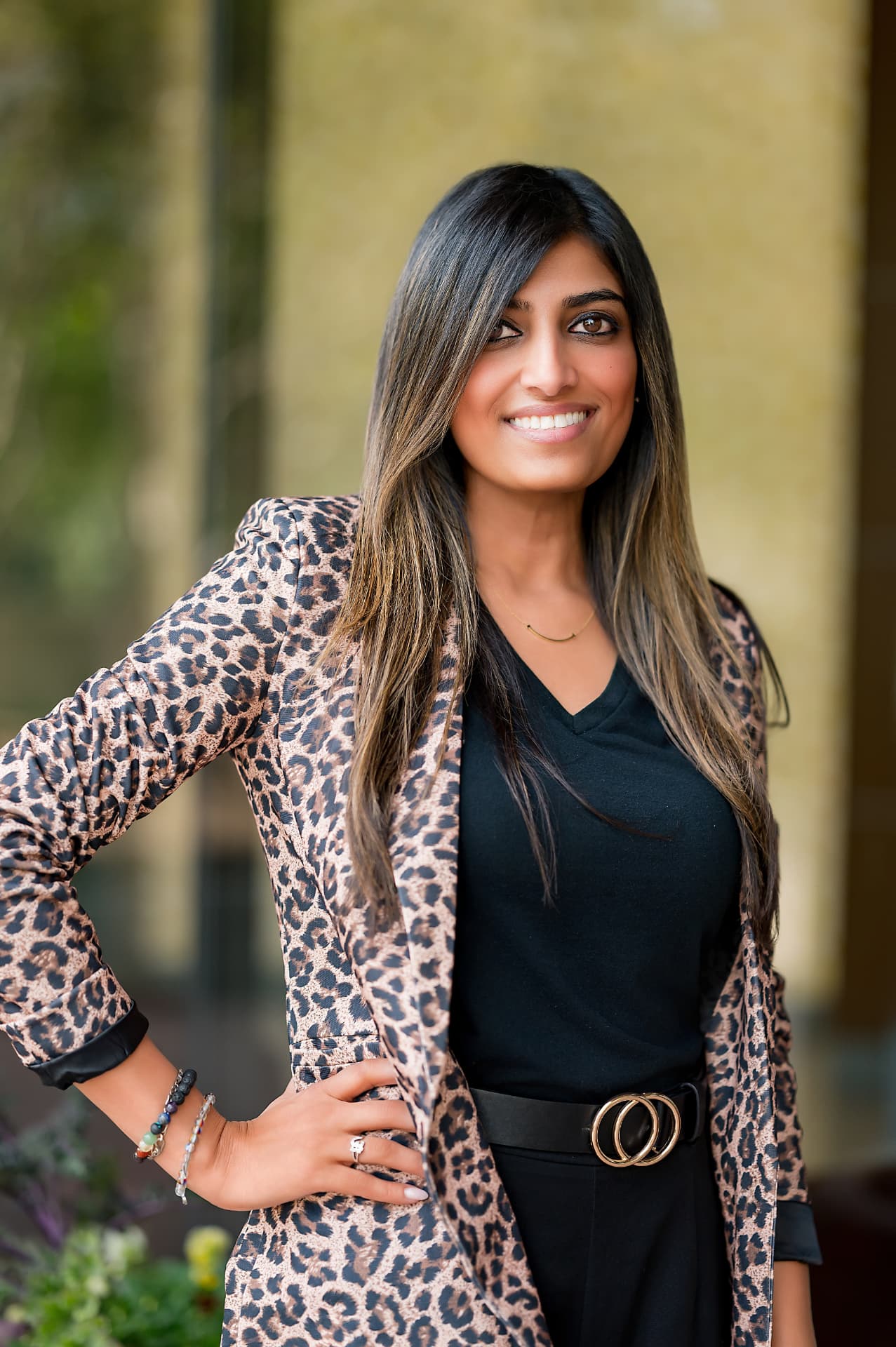 Business portrait of a woman in a leopard-print blazer outside an office