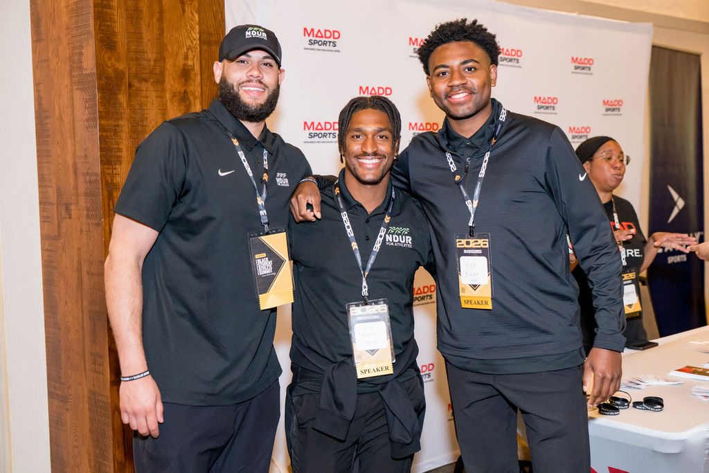 Three NDUR for Athletes speakers at the MADD Sports backdrop
