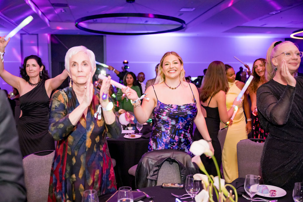 Guests applauding with glow sticks during the program
