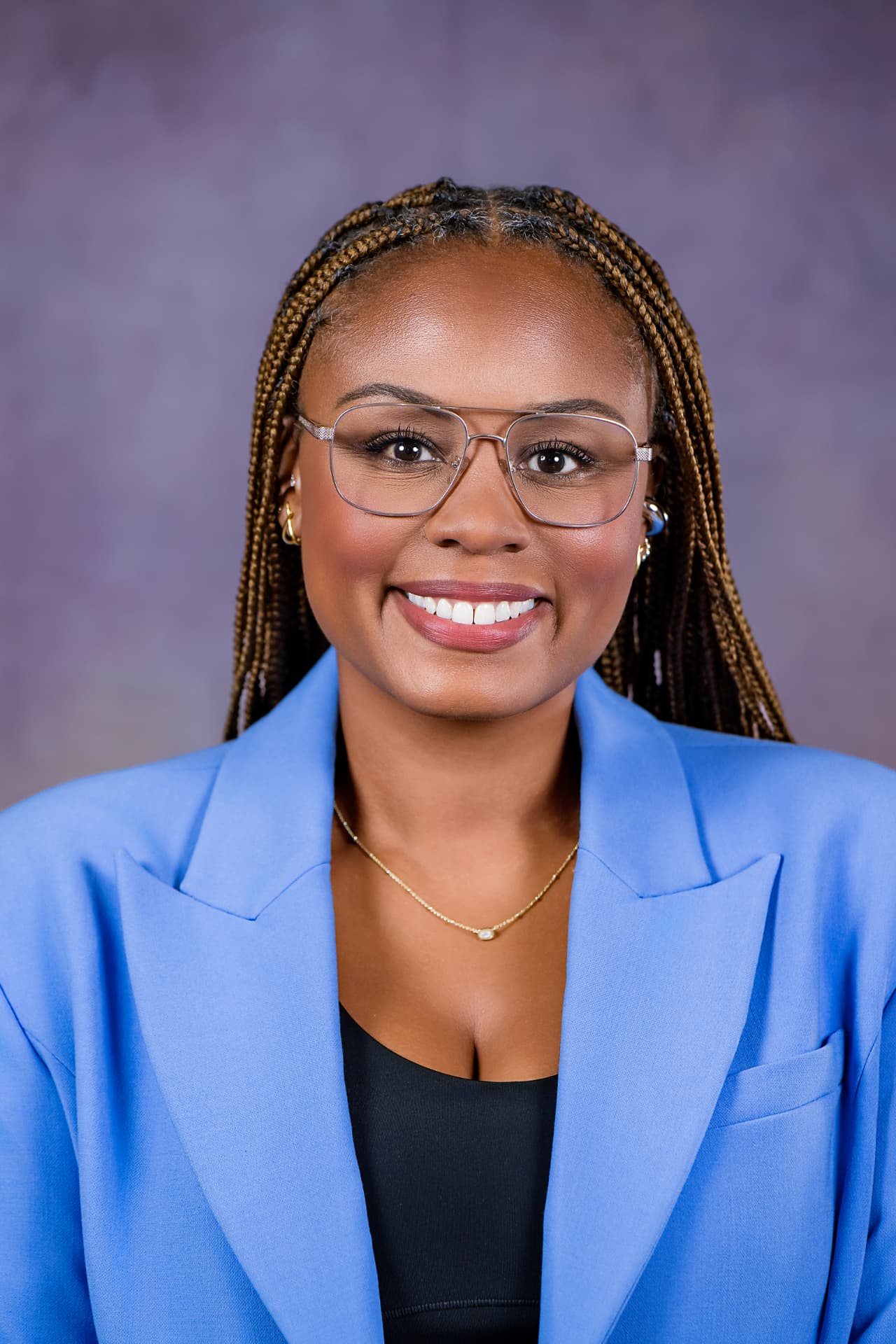 Studio headshot of a professional woman in a light blue blazer