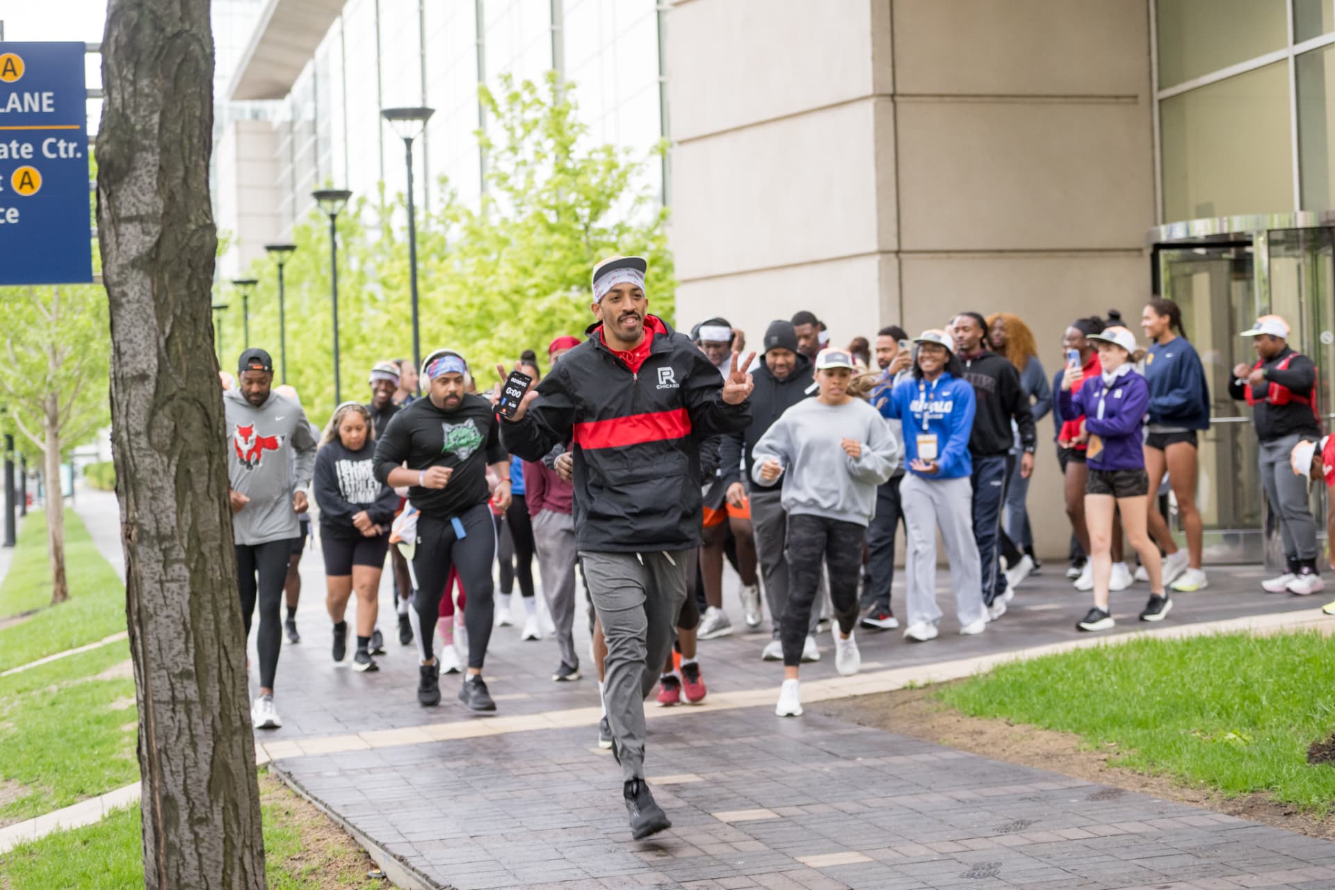 Run leader smiling at the front of a group run outside the venue