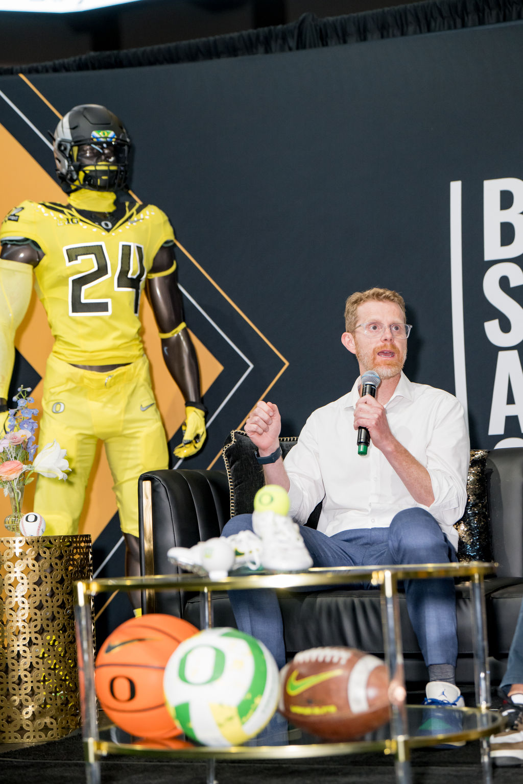 Panelist speaking with Oregon sports memorabilia in the foreground