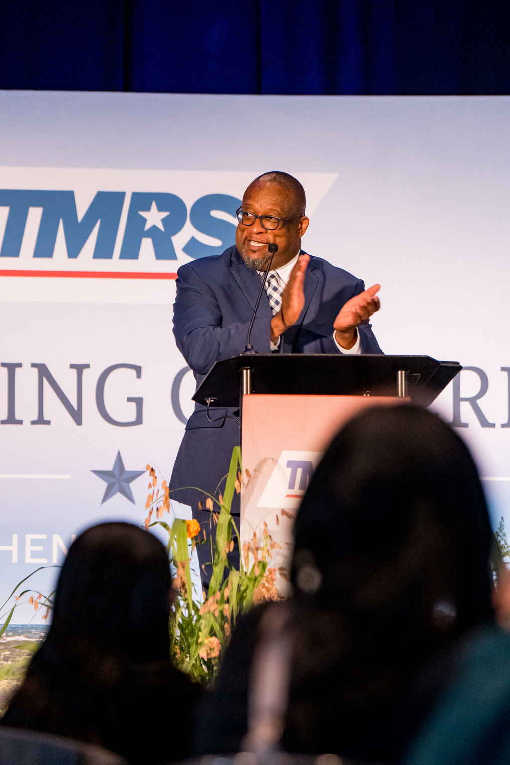Speaker applauding from the podium during the TMRS general session