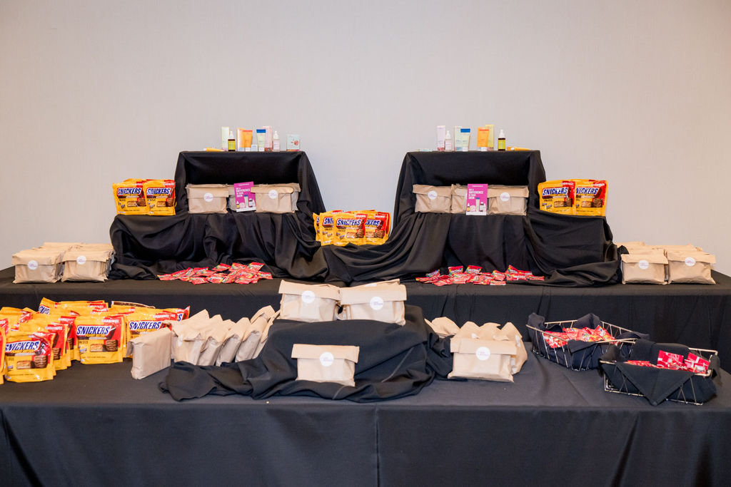 Sponsor gifting table styled with tote bags, snacks, and product samples at the BSA Summit