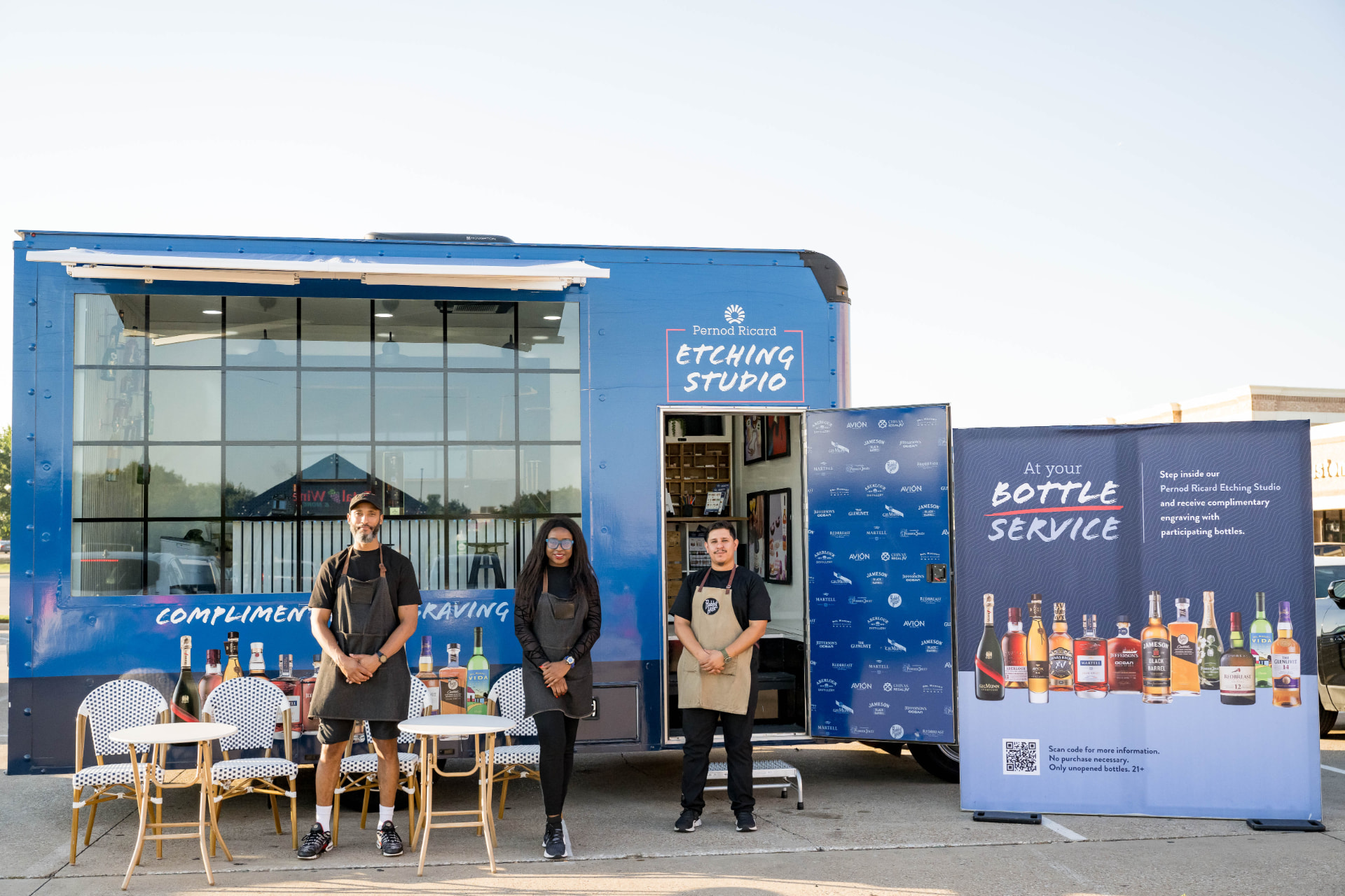 Brand activation team standing outside a mobile etching studio trailer