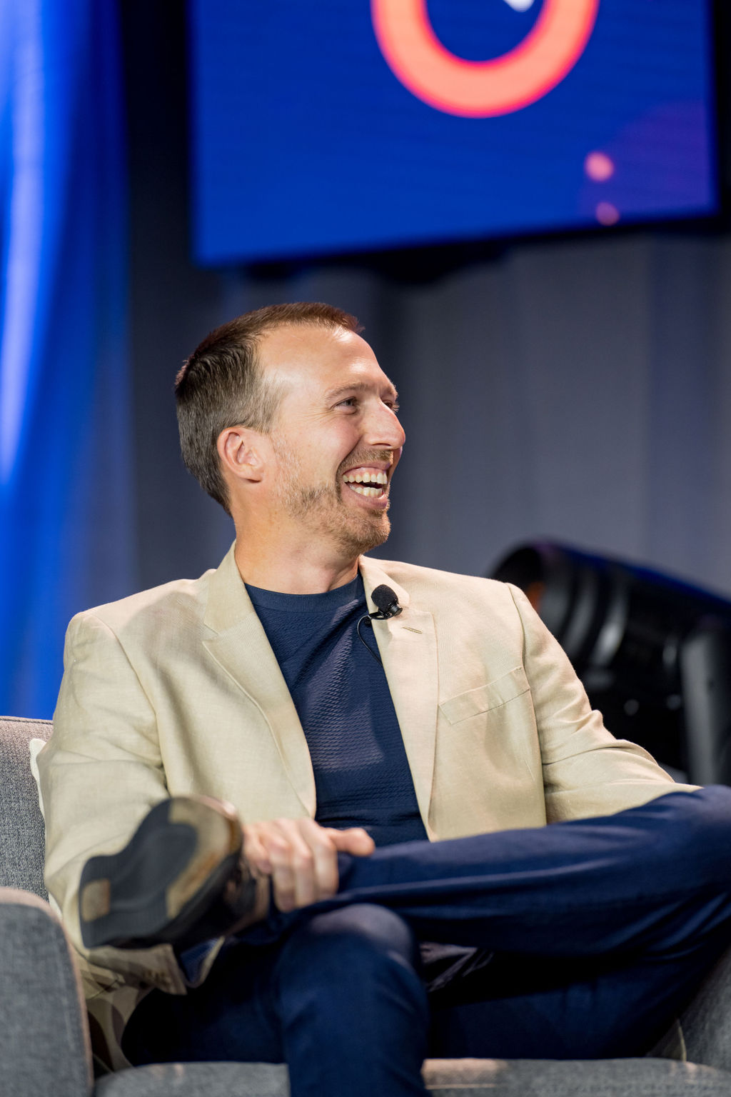 Guest speaker laughing during an on-stage conversation at Limitless Expo