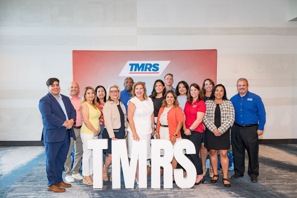 Group portrait of the TMRS team behind large white TMRS letters in Austin, Texas