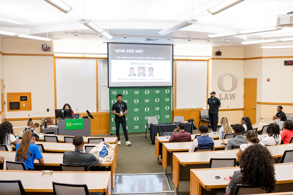 Speaker presenting to attendees in the University of Oregon law lecture hall