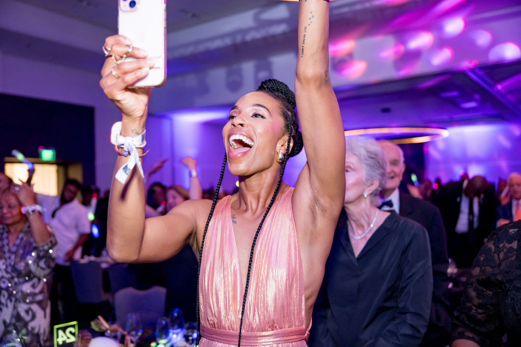Guest cheering with her phone raised during the celebration