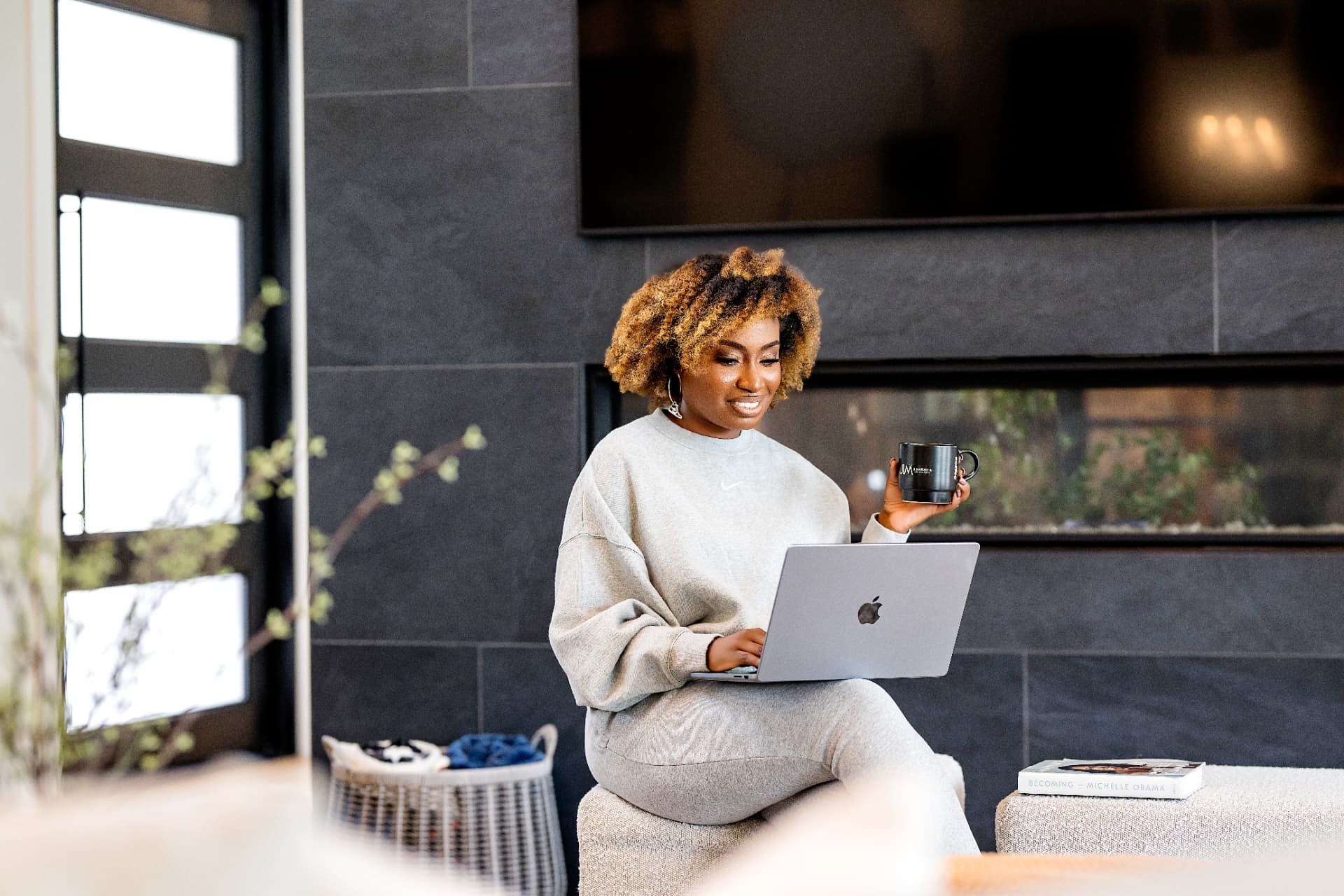 Entrepreneur working on a laptop with a branded mug at home