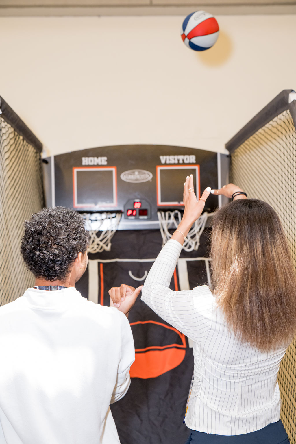 Attendees shooting hoops at the arcade basketball activation