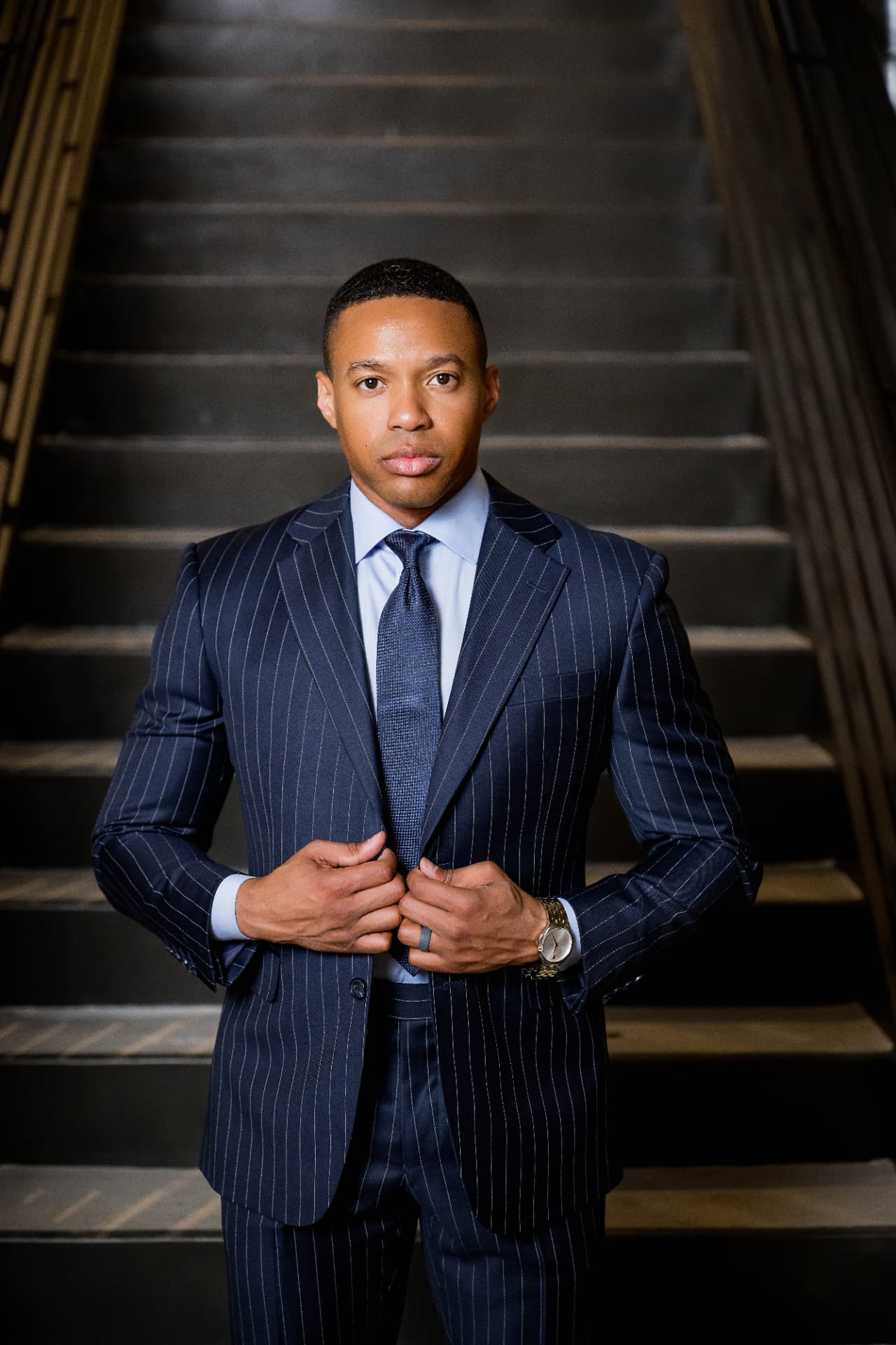 Executive in a pinstripe suit on a dark stairwell