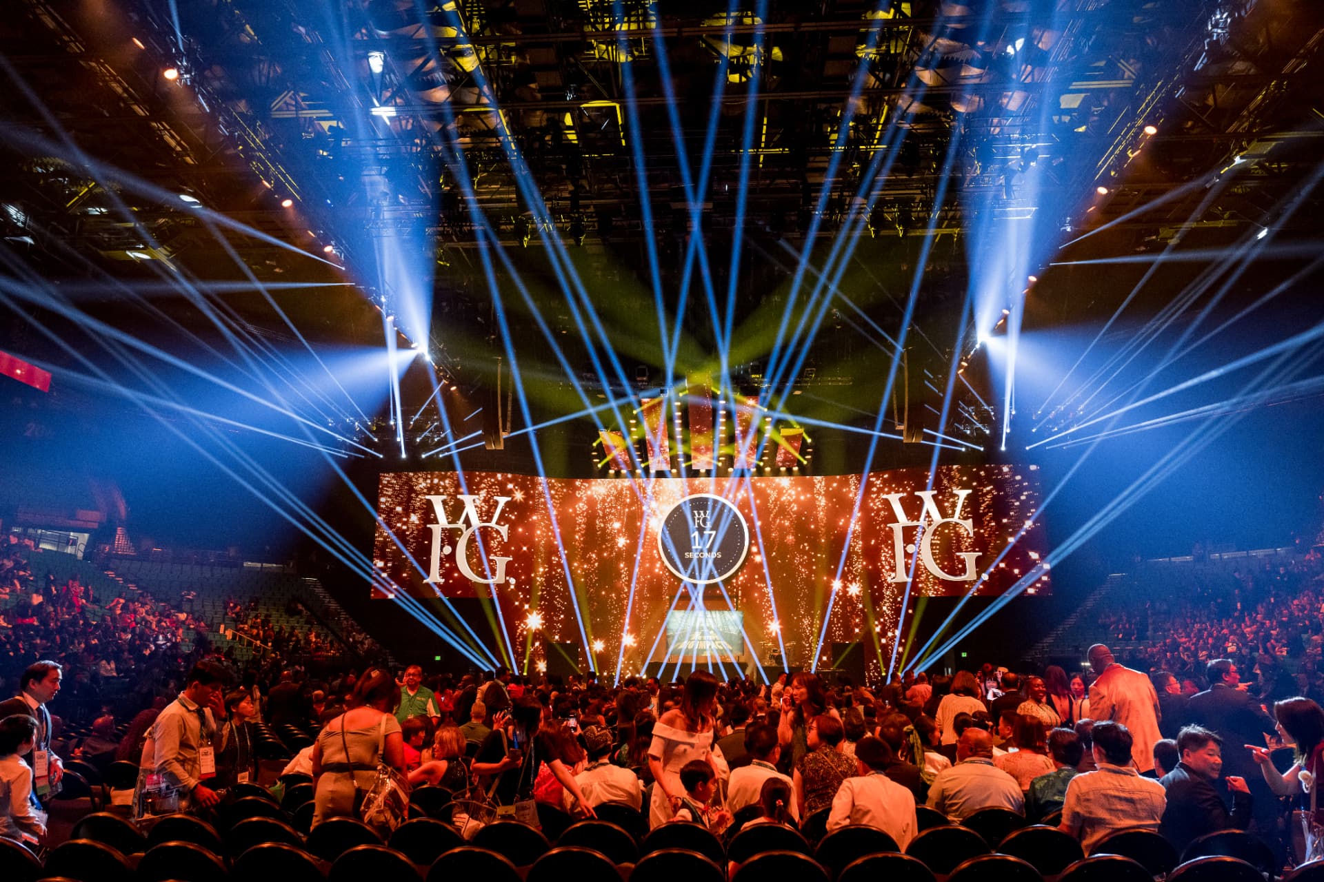 Arena general session with laser lighting and a packed crowd