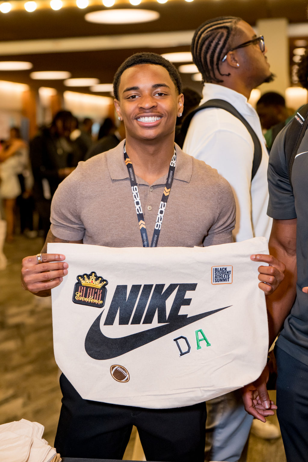Student athlete holding a custom Nike tote bag at the BSA Summit