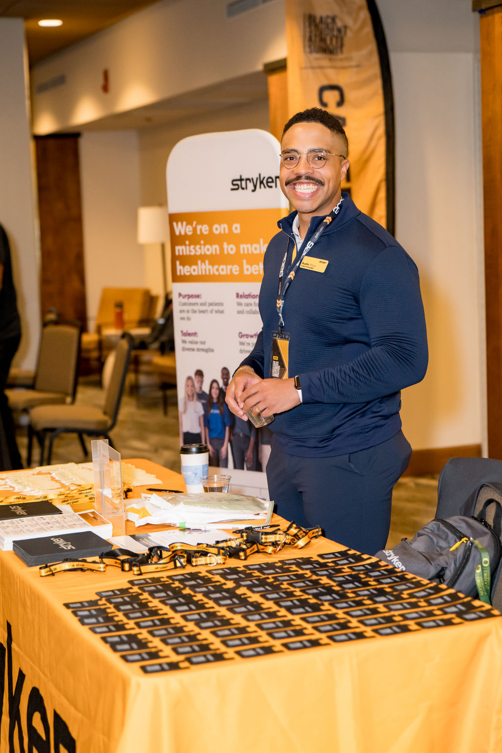 Stryker representative welcoming attendees at the sponsor table