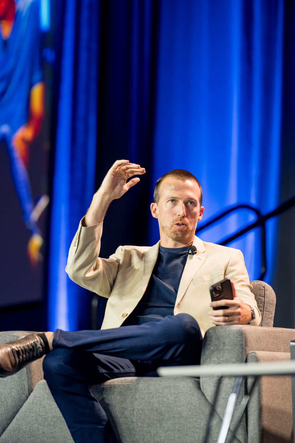 Speaker gesturing while seated on the Limitless Expo main stage