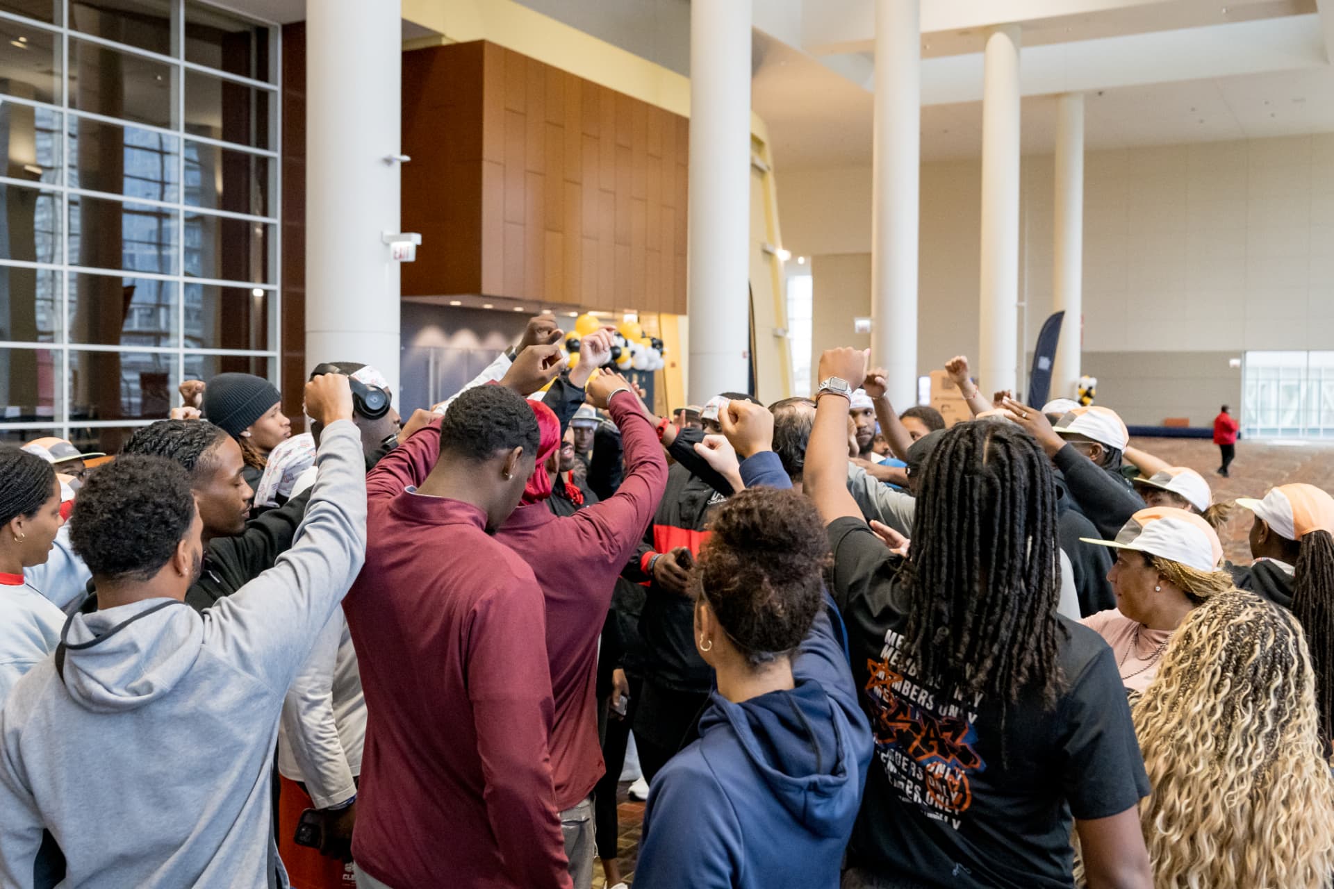 Attendees raising their fists together in a circle